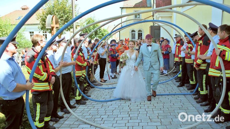 Freudestrahlend durchschreiten die Brautleute Melanie und Fabian das Ehrenspalier zahlreicher Vereine. Bild: ban