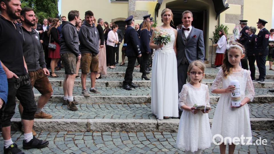 Carina Bauer und Michael Donhauser beim Verlassen der Pfarrkirche, vorne die beiden Brautkinder Lina und Nora. Links ein Teil des Vereins "Schwazabecha Haisl". Bild: kro