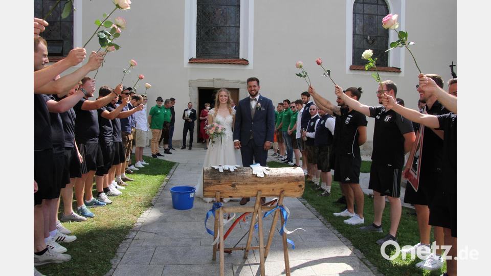 Vera Reichenberger und Dominik Wolf freuten sich nach der Trauung über ein großes Ehrenspalier, gebildet von Fußballern des SV Pechbrunn-Groschlattengrün und des TSV Konnersreuth. Bild: kro