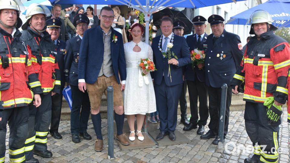 Celine Reber und Hans Fick schlossen am frühen Samstagnachmittag im Rathaus in Mitterteich den standesamtlichen Bund der Ehe. Nach der Zeremonie, die von Bürgermeister Stefan Grillmeier (mit Amtskette) geleitet wurde, wurde das Paar von einer stattlichen Abordnung von der Feuerwehr Mitterteich erwartet. Bild: jr