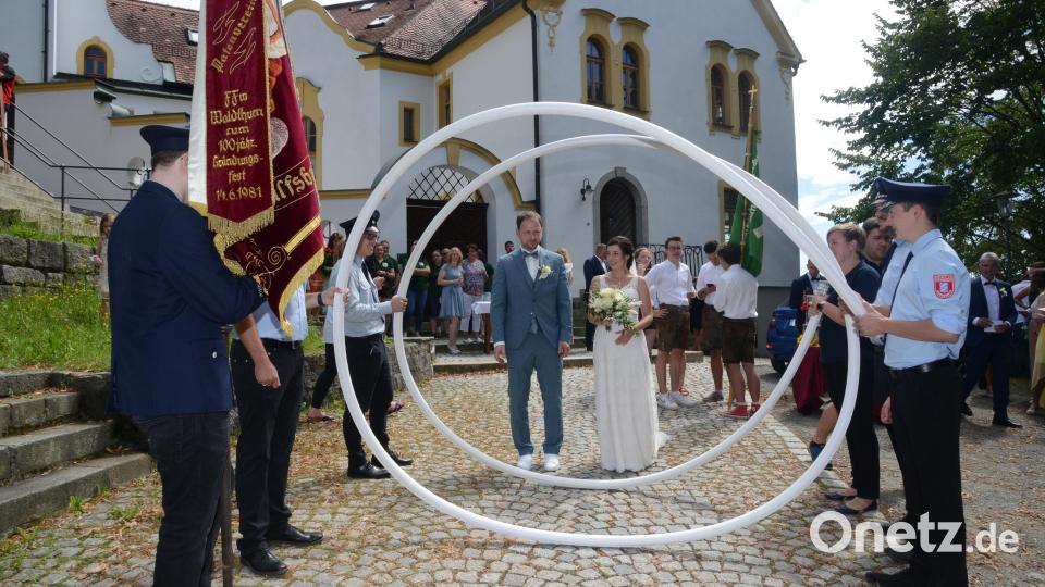 Markus und Karina Schwandner dürfen durch einen Ring aus Feuerwehrschläuchen gehen. Bild: bey