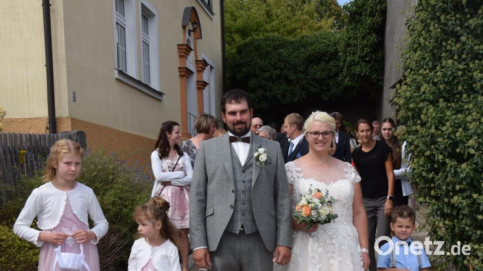 Kevin Deinzer und Janine Lösch erwarteten nach der Trauung viele Freunde und schaulustige Kürmreuther, die das Brautpaar hochleben ließen. Bild: wku