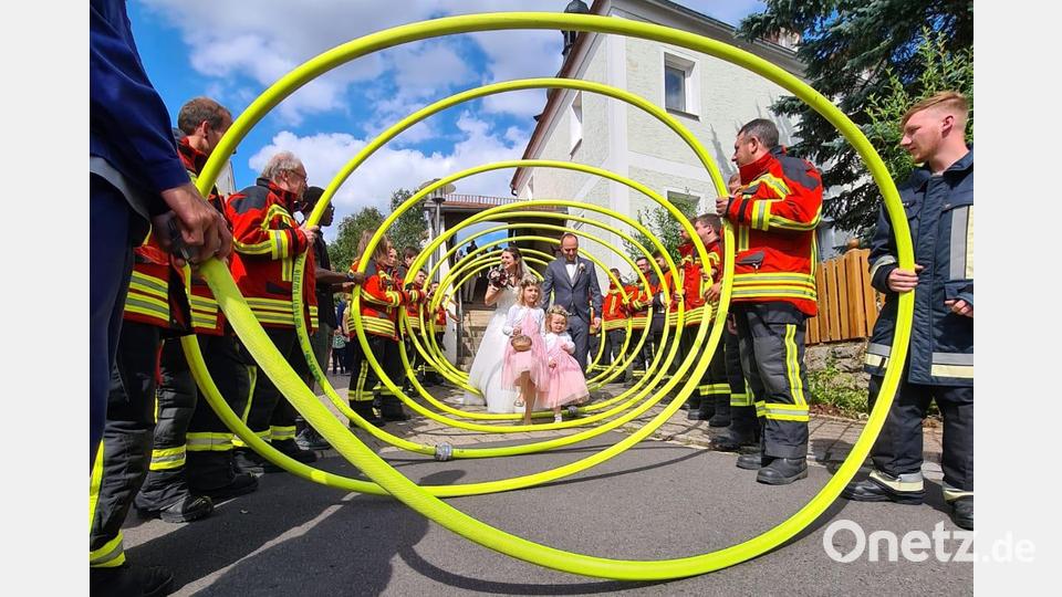 Das Brautpaar beim Durchschreiten des Schlauch-Spaliers der Feuerwehren. Bild: rwo