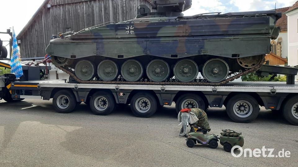 Der neue Schwerlasttransporter schleppt einen Panzer Marder (rechts). Winzig erscheint dagegen das olivgrüne Bobby-Car, hier mit dem Maskottchen, einen Elefanten in Uniform. Bild: oe