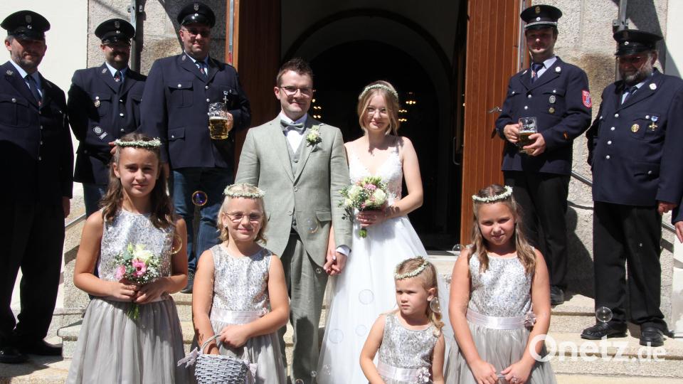 Alicia und Christian Trießl beim Verlassen der Pfarrkirche mit den Brautmädchen Nele, Leonie, Marie und Lorena sowie der Feuerwehr Voitenthan. Bild: kro