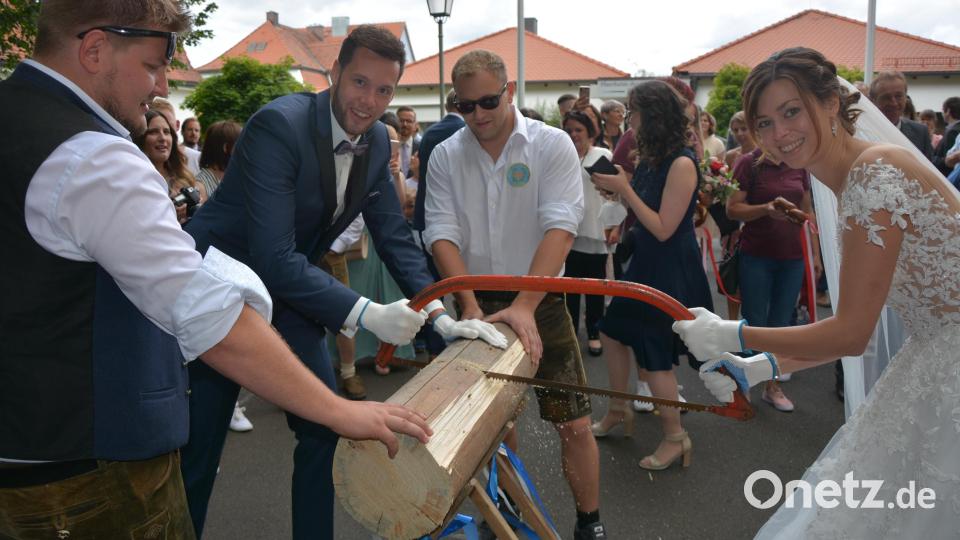 Nicht ganz einfach gestalteten sich die Säge-Arbeiten mit einem präparierten Werkzeug, die das Brautpaar auf Veranlassung des Burschenvereins Pechbrunn vornehmen musste. Bild: jr