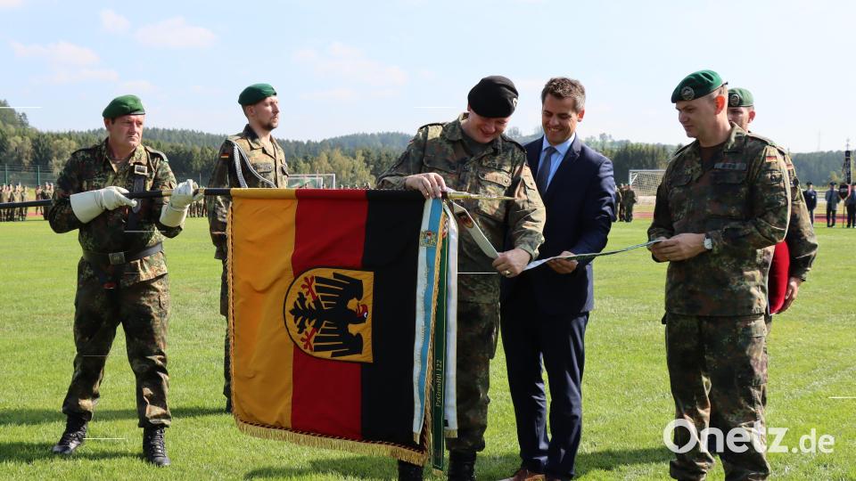 Zusammen mit dem Bürgermeister der Stadt Oberviechtach, Rudolf Teplitzky (Zweiter von rechts), und dem Kommandeur des Panzergrenadierbataillons 122, Ralf Georgi (erster von rechts) verleiht Divisionskommandeur Ruprecht von Butler (Mitte) das Fahnenband in Anerkennung für die Einsätze des Verbandes. Bild: Bundeswehr/ Lihring/exb