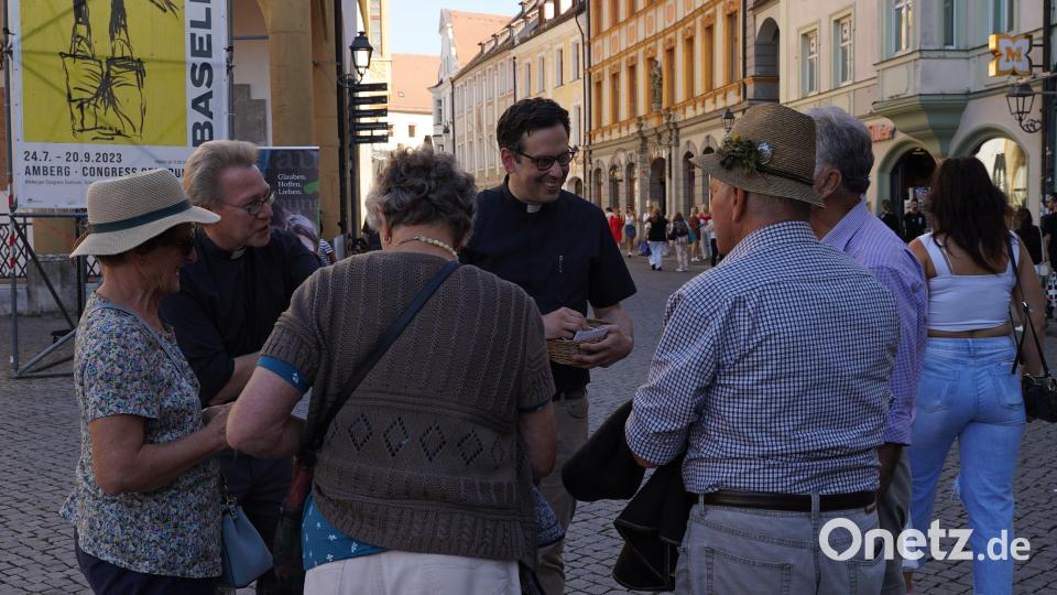 Dekan Dr. Christian Schulz (hinten, links) und Pfarrer Dominik Mitterer (hinten, rechts) im Gespräch mir Passanten beim Aktionstag des Dekanats auf dem Amberger Marktplatz. Bild: Regina Probst/exb