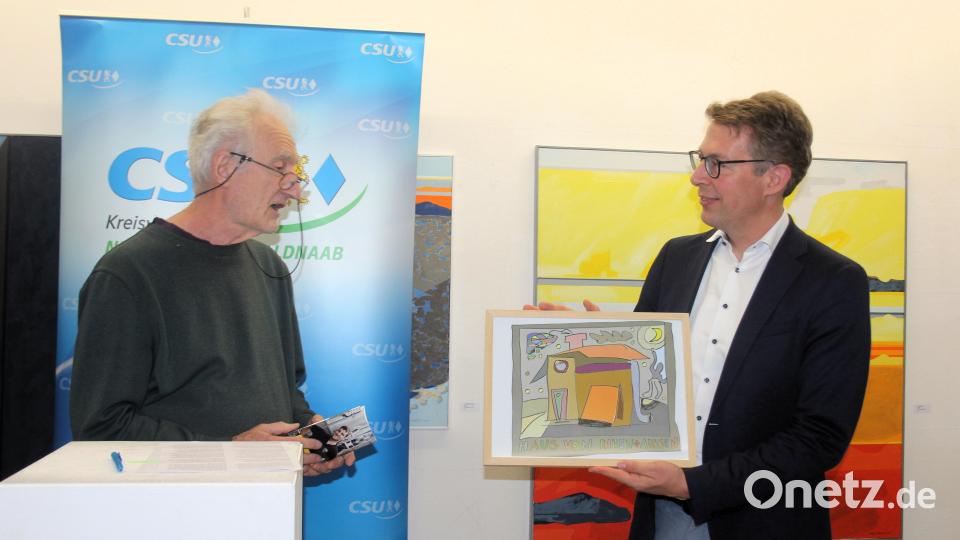 Wolfgang Herzer (links) vom Kunstverein überreicht ein Kunstwerk an Kunst- und Wissenschaftsminister Markus Blume. Bild: stg