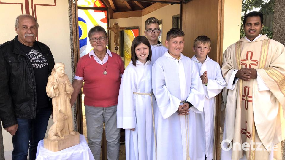 Gabi Eichenseher, Eigentümerin der Kapelle in Mühlhof, Künstler Manfred Dietz (links), einige Ministranten von Sankt Michael und Pater James mit der neuen Heiligenfigur nach deren Segnung. Bild: wro