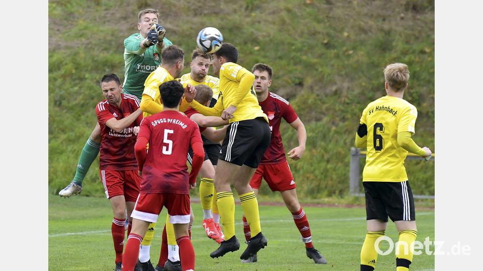 Nach einer Hahnbacher Ecke faustet der Pfreimder Torhüter Michael Herrmann den Ball aus der Gefahrenzone. Der zweifache Elfmetertorschütze Manuel Plach, Tobias Hüttner, Johannes Dotzler und Kapitän Michael Hefner (gelbe Trikots, von links) vom SV Hahnbach sind in Alarmbereitschaft. Bild: Hubert Ziegler