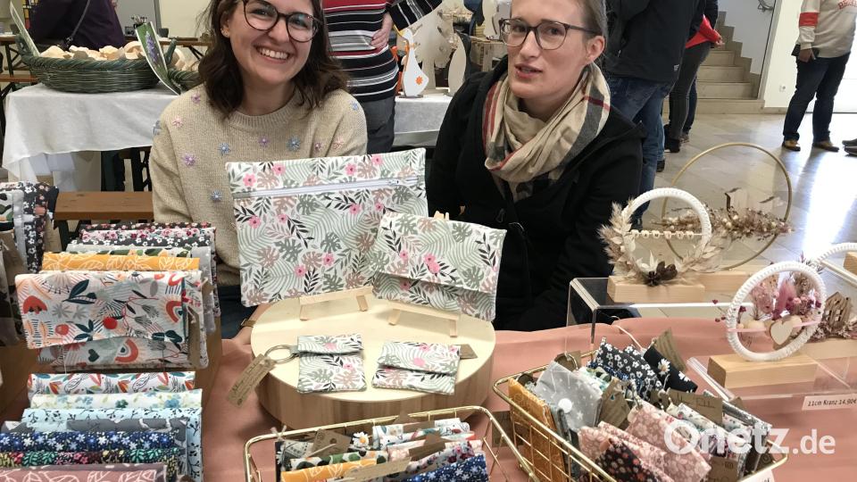 Junge Frauen bieten beim Herbstmarkt feine Näharbeiten an. Bild: mma