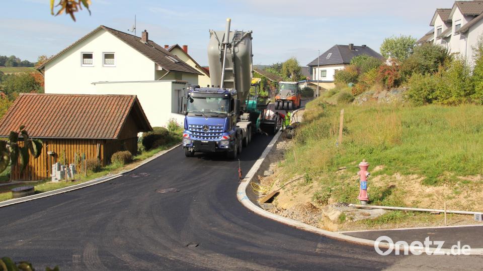 Endspurt beim Auftragen der Deckschicht im Brünnlweg, hier an der Einmündung in die Dietersdorfer Straße. Bild: boj