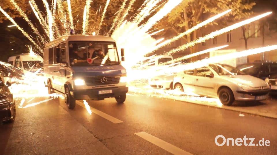 Feuerwerkskörper fliegen hinter einem Polizeiauto bei einer nicht angekündigten pro-palästinensischen Demonstration in Neukölln. Bild: -/TNN/dpa