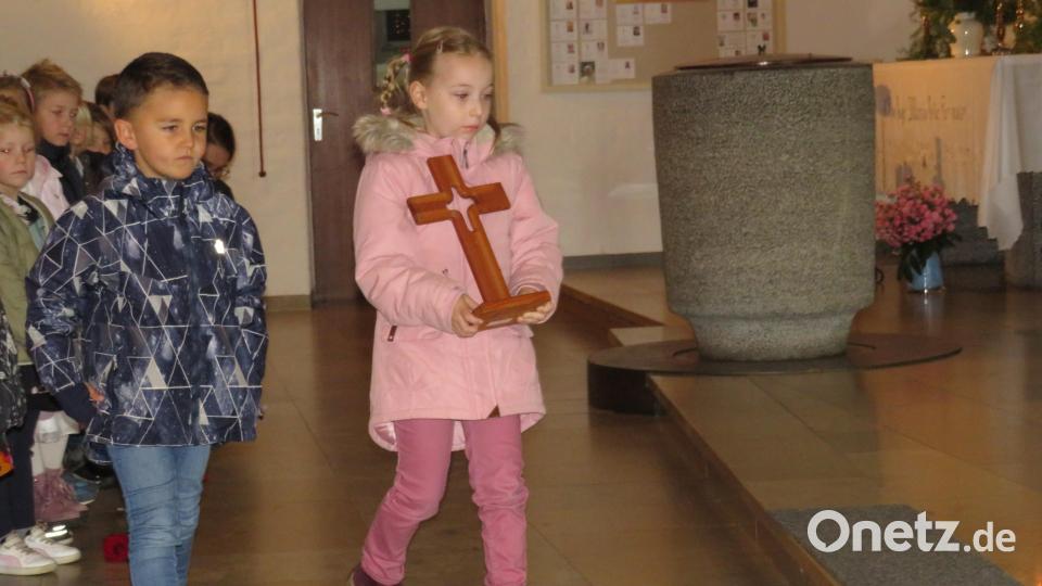 Einen Koffer voller Erinnerungen und andere Gegenstände brachten die Kinder zum Altar. Bild: adj