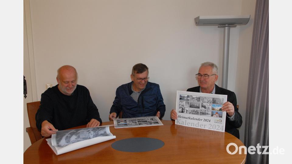 Josef Popp stellt im Rathaus den beiden Bürgermeistern Peter Braun und Martin Bauer den neuen Heimatkalender des Marktes vor. Bild: pop
