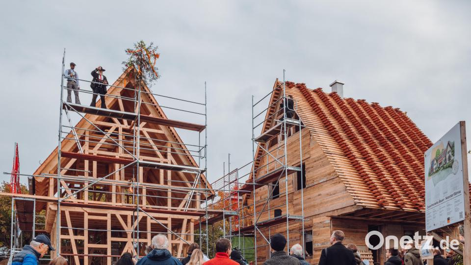 Zimmerermeister Armin Mannschott (oben rechts) sprach den Richtspruch für das vierte Haus der Naturdorf-Siedlung beim Geschichtspark Bärnau. Steinmetz Robert Mois (oben links) unterstützte ihn. Gäste begleiteten die feierliche Zeremonie. Bild: Susanne Forster