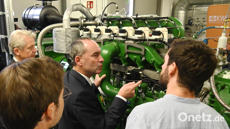 Max Becker, Wissenschaftlicher Mitarbeiter im Kompetenzzentrum der OTH (rechts) erklärt Bayerns Vizeministerpräsident Hubert Aiwanger (vor der Anlage) das neue Wasserstoff-Blockheizkraftwerk am Campus. Mit dabei waren auch Clemens Bulitta, Präsident der OTH Amberg-Weiden (links) und Professor Raphael Lechner. Bild: gf