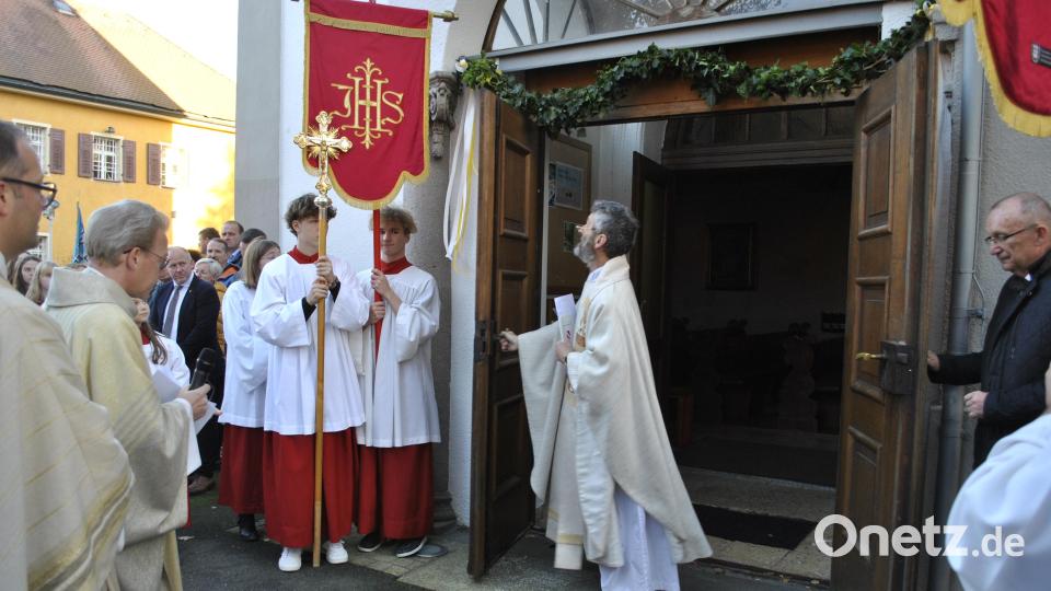 Dekan Christian Schulz (Zweiter von links) forderte den neuen Stadtpfarrer Helmut Brügel auf, das Kirchenportal für seine Pfarrgemeinde symbolisch zu öffnen. Bild: wfw
