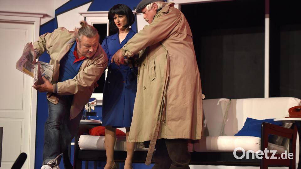 Wie ein Rugbyspieler versucht Stanley (Jens Ulrich Seffen) die Ausgabe des „New Day“ mit dem verräterischen Artikel über Johns Unfall in Sicherheit zu bringen. Mary (Mica Bara) und der Inspektor (Gerhard Kühner) wundern sich. Bild: Tobias Schwarzmeier