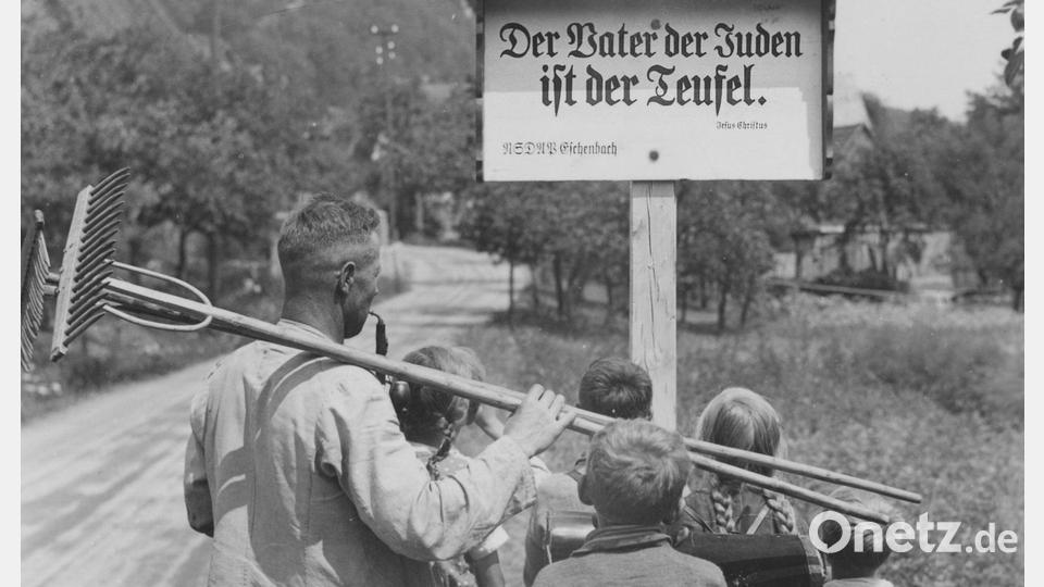 Judenfeindliches Schild am Ortseingang der früheren Gemeinde Eschenbach (jetzt Gemeinde Pommelsbrunn) im Jahr 1935 – zudem Titelbild des Buches von Tilman Tarach „Teuflische Allmacht“. Bild: Stadtarchiv Nürnberg, E 39/I Nr. 2248/25