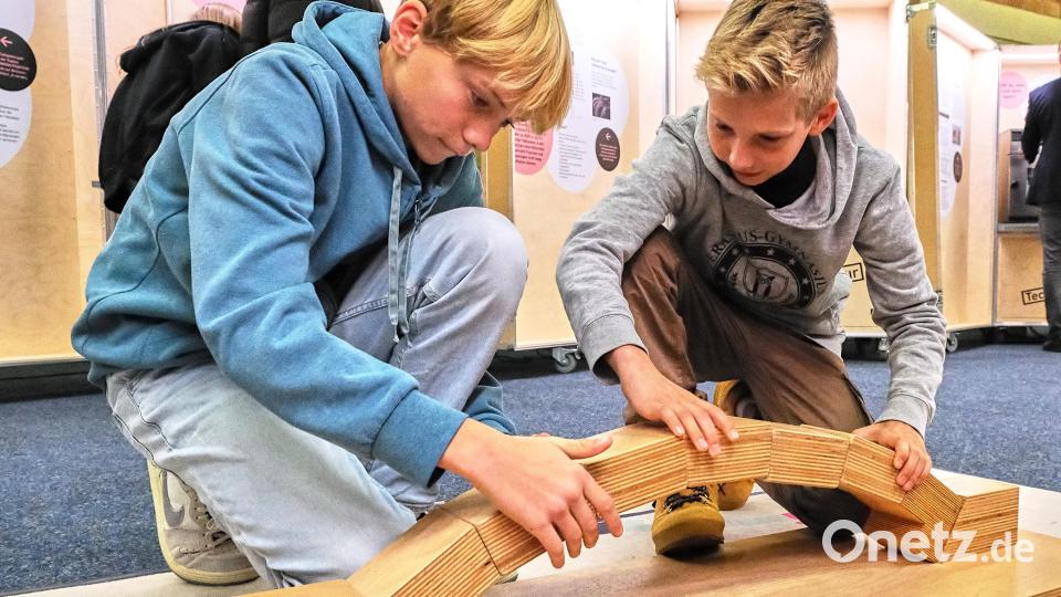 Jonas und Felix (von links) setzen aus Holzbausteinen einen Brückenbogen zusammen und testen hinterher, ob man darauf stehen kann. Bild: Peter Ringeisen