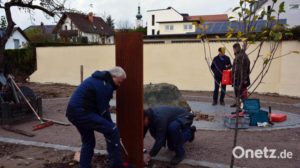 Eine der drei neuen Poesiestelen wird im „Obstgarten“ montiert. Bild: Helmut Langhammer/exb