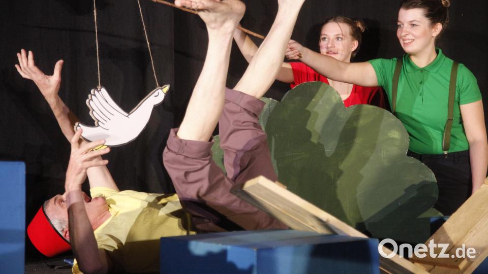 Schneider Böck (Josef Götz) stürzt in den Bach. Max und Moritz (Anna Götz und Lea Starkmann) haben die Brücke angesägt. Die Gänse helfen ihm aus dem Wasser. Bild: Hirsch