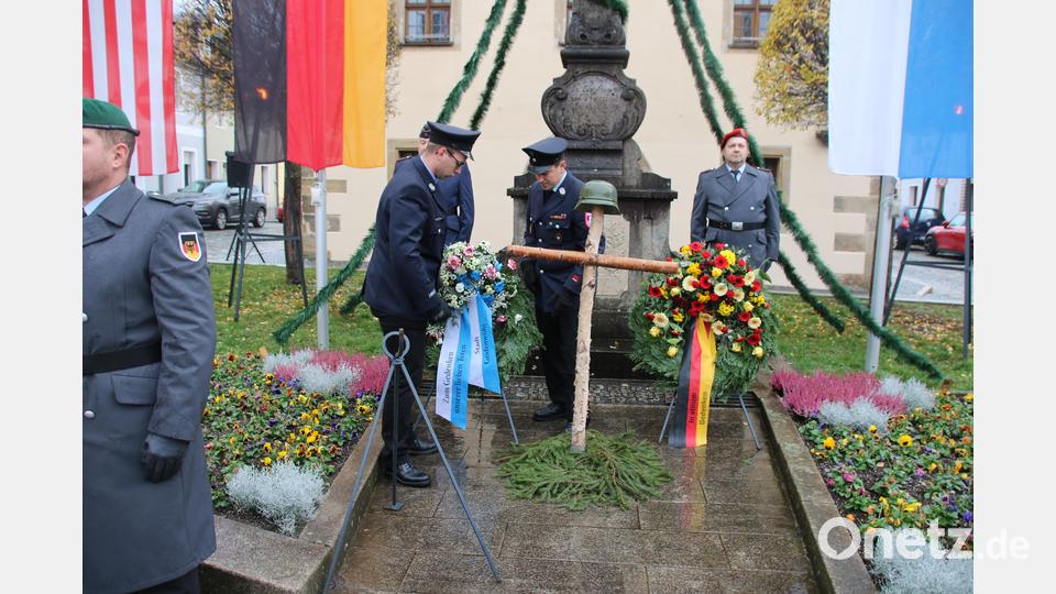 Angehörige der Feuerwehr legen einen Kranz nieder. Bild: sne