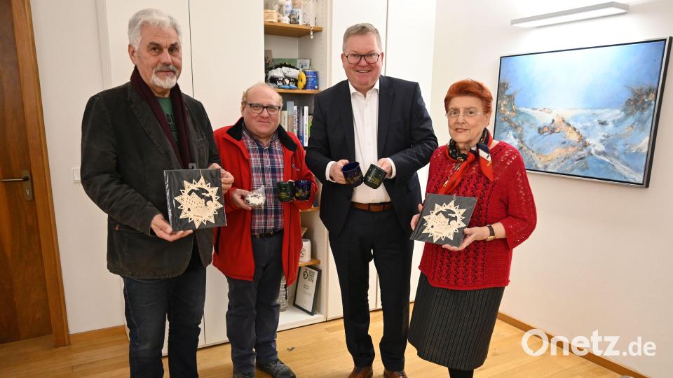 Oberbürgermeister Michael Cerny (Zweiter von rechts) und die PWG-Vorstandschaft (von links): Andreas Raab, Peter Harant und Emilie Leithäuser ) bei der Präsentation der neuen Weihnachtsmarkttasse im Amberger Rathaus. Bild: Simon Hauck, Stadt Amberg/exb