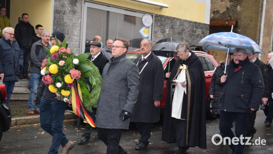 Die Markträte Georg Stahl (links) und Michael Troidl (rechts) tragen den Kranz, der später am Ehrenmal niedergelegt wird. Bild: fla