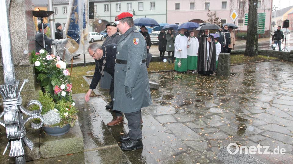 Bürgermeister Markus Bauriedl (mit Amtskette) legt am Kriegerdenkmal einen Kranz nieder. Bild: pi
