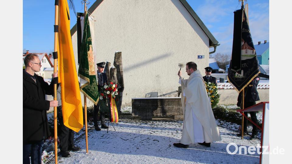 Pfarrer Daniel Fenk segnet die Kränze. Bild: sne