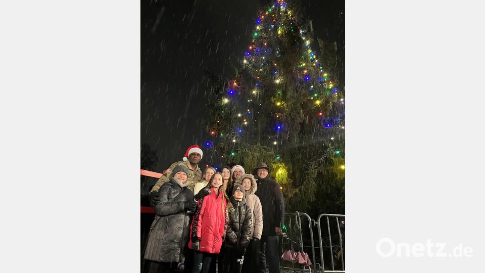 Schneefall und bunte Lichter am Weihnachtsbaum brachten richtiges Weihnachtsfeeling. Bürgermeister Edgar Knobloch (rechts) mit General Carpenter und Oberst Poole und ihren Familien. Bild: mor