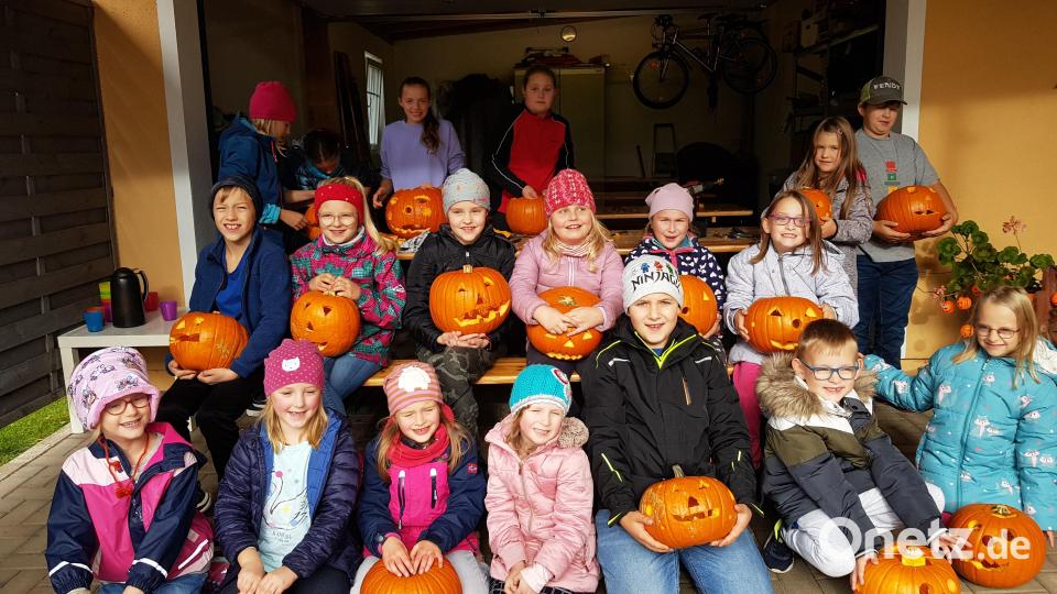 Die Buben und Mädchen zeigen ihre selbstgeschnitzten Halloween-Kürbisse. Bild: gi