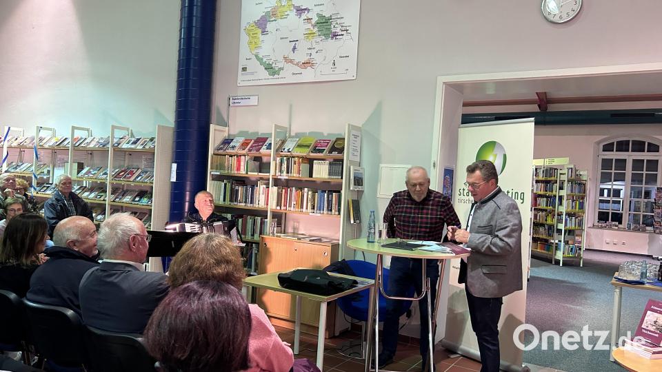 Autor Siegfried Fuchs (stehend, links) kam auf Einladung von Maximilian Schön (stehend, rechts), Vorsitzender des Stadtmarketingvereins, gerne für eine Lesung nach Tirschenreuth. Viktor Ehlscheid (sitzend, links) umrahmte am Akkordeon die Veranstaltung musikalisch. Bild: Stadtmarketing Tirschenreuth/exb