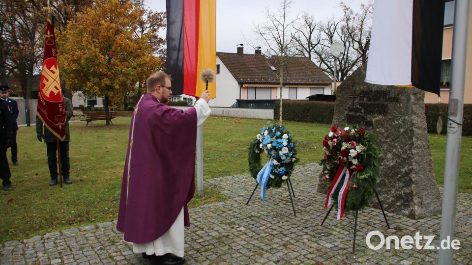 Pfarrer Daniel Fenk segnet die Kränze vor dem Gedenkstein. Bild: sne