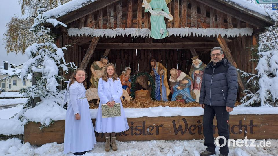 Christkind Emma (rechts) und Engelchen Anna (links) mit Bürgermeister Franz Tauber an der kunstvollen Krippe in der Dorfmitte. Bild: gis