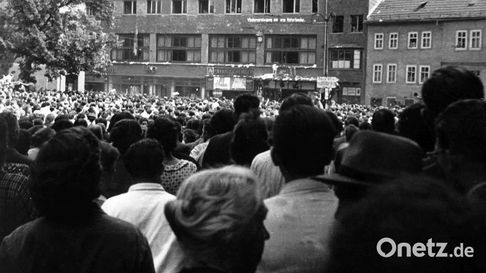 Demonstranten stehen am 17.06.1953 auf dem Holzmarkt in Jena vor dem Gebäude der SED. Archivbild: dpa