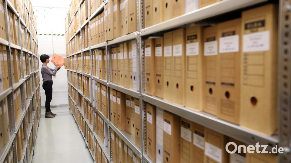 Jede Akte kann eine tragische Geschichte bergen. Eine Frau steht vor einer Regalreihe mit Akten aus einer ehemaligen Stasi-Kreisdienststelle. Archivbild: Bernd Wüstneck