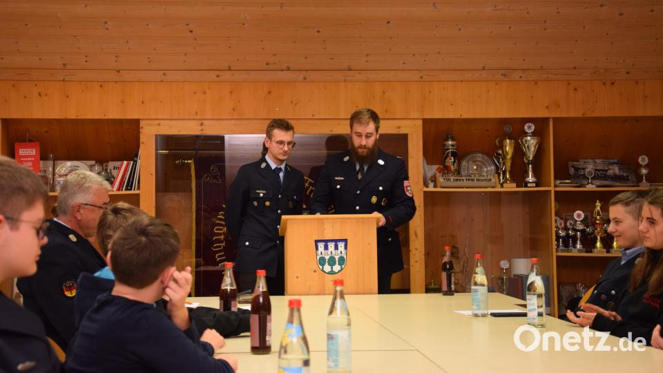 Jugendwart Josef Pflaum junior (rechts, am Rednerpult) und Noch-Jugendsprecher Lukas Kleber begrüßen zur Mitgliederversammlung der Jugendfeuerwehr und berichten über die vergangenen drei Jahre. Bild: fla