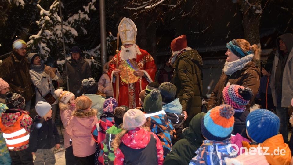 Der Nikolaus (Markus Arnold) beschenkte die Kinder am Königsteiner Weihnachtsmarkt, nachdem sie ihm einige Lieder gesungen hatten. Bild: wku