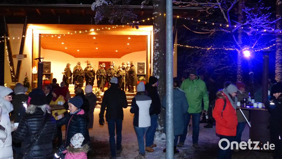 Dank des Schneefalls herrscht bei der Waldweihnacht in Weiherhammer eine Kulisse wie im Film. Für die passende Musik sorgt die Jagdahornbläsergruppe Weiden-Neustadt (im Hintergrund auf der Bühne). Bild: hme