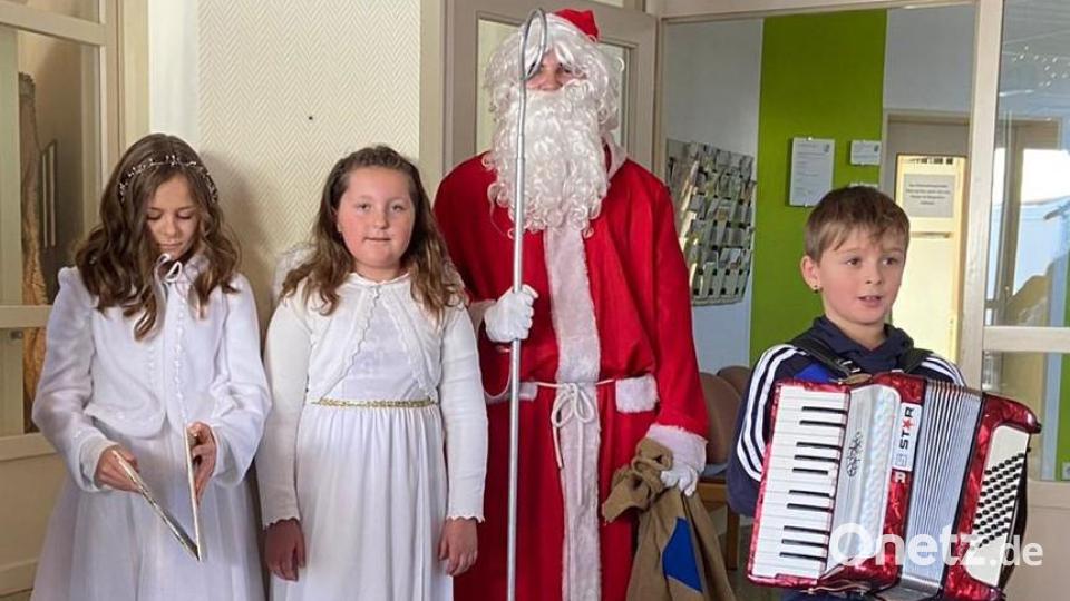 Christkind Emma Hautmann (von links) und Engelchen Anna Lehnert mit dem Nikolaus und Musiker Jonathan Voit. Bild: Richard Ehlich/exb