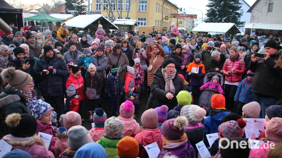 Kinder, Eltern und andere Gäste des Christkindlmarkts lauschten auf Kerstin Farmbauer und dem Kinderchor. Bild: sne