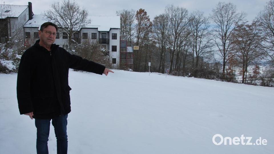 Norbert Vogl vom Landratsamt Amberg-Sulzbach zeigt die 1000 Quadratmeter große Fläche direkt neben dem Schwesternwohnheim der St. Johannes-Klinik in Auerbach, die aus Sicht des Landkreises für den Bau einer Asyl-Unterkunft geeignet wäre. Bild: gsp