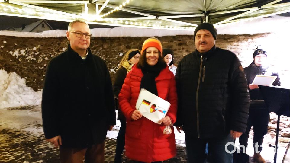 Jan Šícha, Veronika Hofinger und Bürgermeister Richard Kreuzer (von links) bringen ihre Gedanken zur Ausstellung am Cebb ein. Im Hintergrund die Sängerinnen und Sänger aus Tachov. Bild: lg