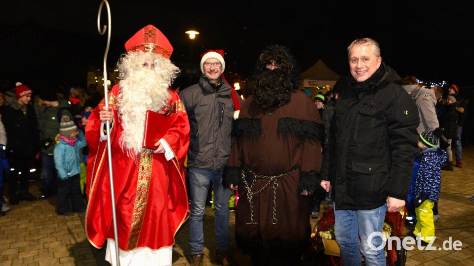 Mit kleinen Geschenken für die Kinder kam der Nikolaus samt Krampus zum Dorfadvent nach Traßlberg. Beim Austeilen helfen der Vorsitzende des Arbeitskreises Dorfleben und Kultur, Dietmar Auers, und Bürgermeister Herrmann Böhm (rechts) mit. Bild: chl
