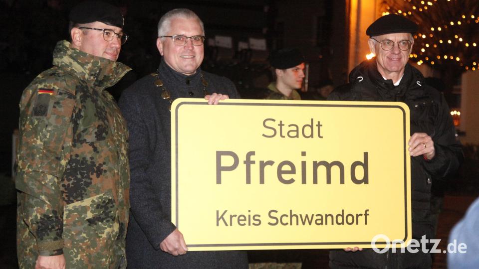Bürgermeister Richard Tischler (Mitte) und Regierungspräsident Walter Jonas (rechts) überreichen Kommandeur Marek Krüger (links) ein Ortsschild der Stadt Pfreimd als symbolisches Zeichen der Verbundenheit zur Truppe. Bild: Hirsch
