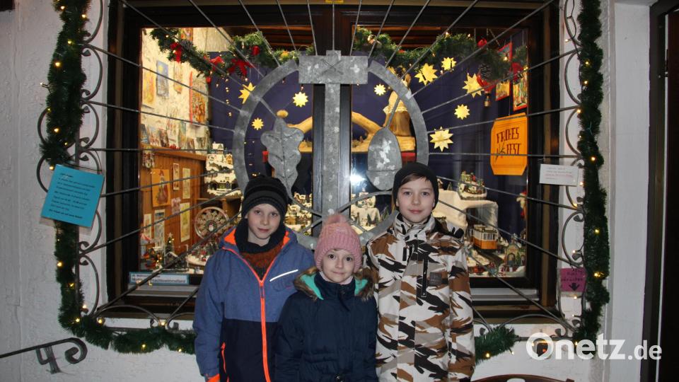 Alexander und Marina Weidner sowie ihr Cousin Andreas Ermer (von rechts) sind stolz auf ihr Weihnachtswimmelland im Weihnachtsfenster von Hans Raß in Letzau. Die KInder hoffen, dass ganz viele Menschen einen Blick darauf werfen. Bild: prh